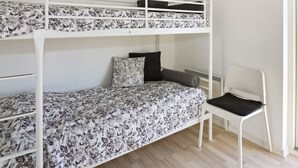 A bunk bed with floral bedding, a chair, and a radiator. - 8 Person Holiday Home in Hadsund (Hadsund)