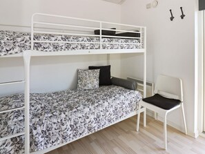 A bunk bed with floral bedding, a chair, and a radiator. - 8 Person Holiday Home in Hadsund (Hadsund)