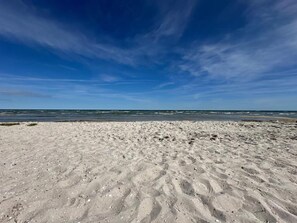 A sandy beach with footprints and a clear blue sky. - 8 Person Holiday Home in Hadsund (Hadsund)