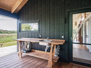 A rustic wooden cabin with a wooden table and sink, a window, and a view of the outdoors. - Luxury Retreat in Silkeborg - By Traum (Engesvang)
