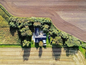 An aerial view of a house surrounded by lush greenery and agricultural fields. - 8 Person Holiday Home in Lokken-by Traum (Lokken)
