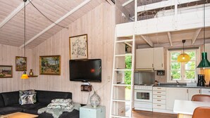 A cozy cabin interior with a living area, a dining space, and a kitchen.