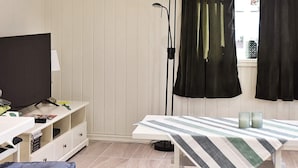 A room with a bed, a TV, a desk, and a window with curtains. - 4 Person Holiday Home in Oksvoll (Orland)