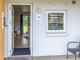 A doorway leading to a room with a window, a doorbell, and a number sign.