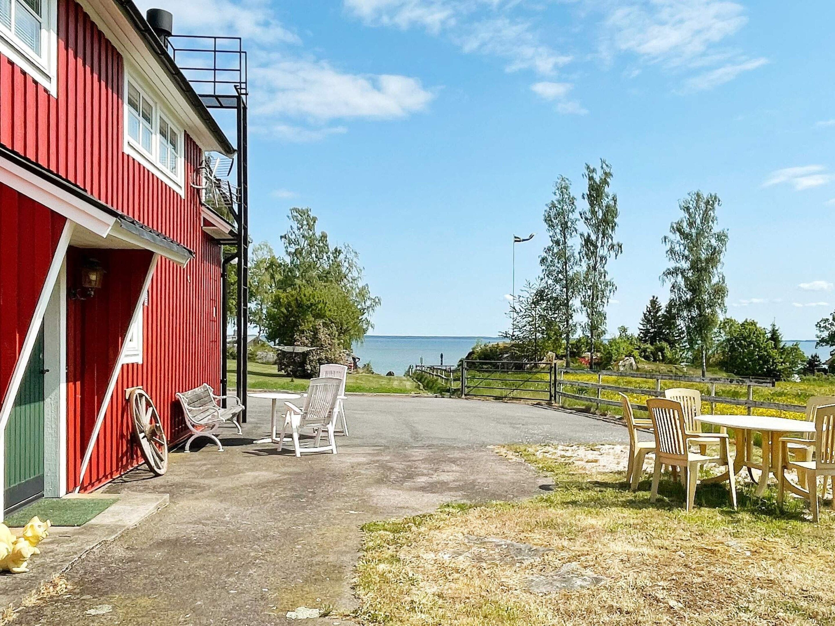A red building with a covered outdoor seating area and a view of the sea.
