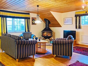 A cozy living room with striped sofas, a fireplace, a television, and a wooden ceiling. - 8 Person Holiday Home in Bralanda (Bralanda)