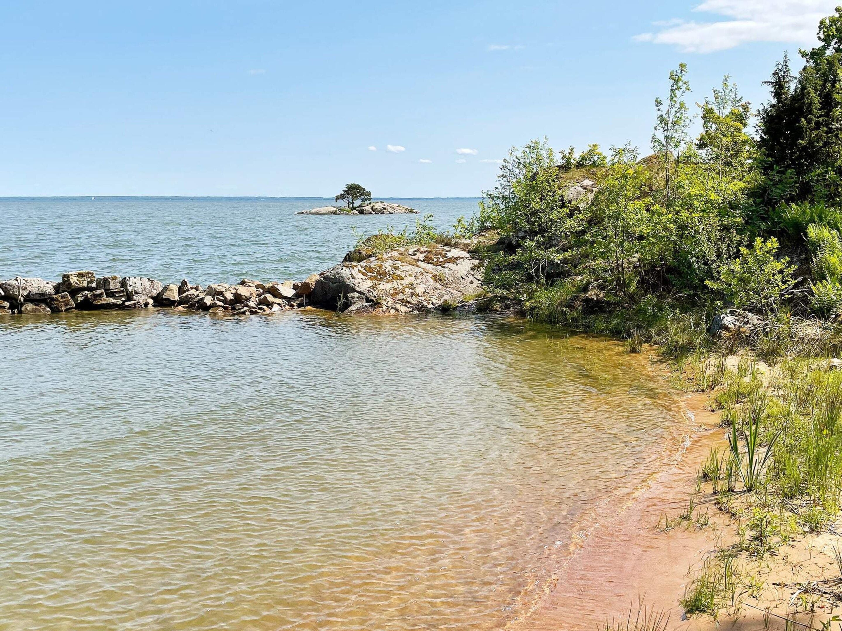 Un paysage côtier caractérisé par une eau claire, une côte rocheuse et une végétation luxuriante.