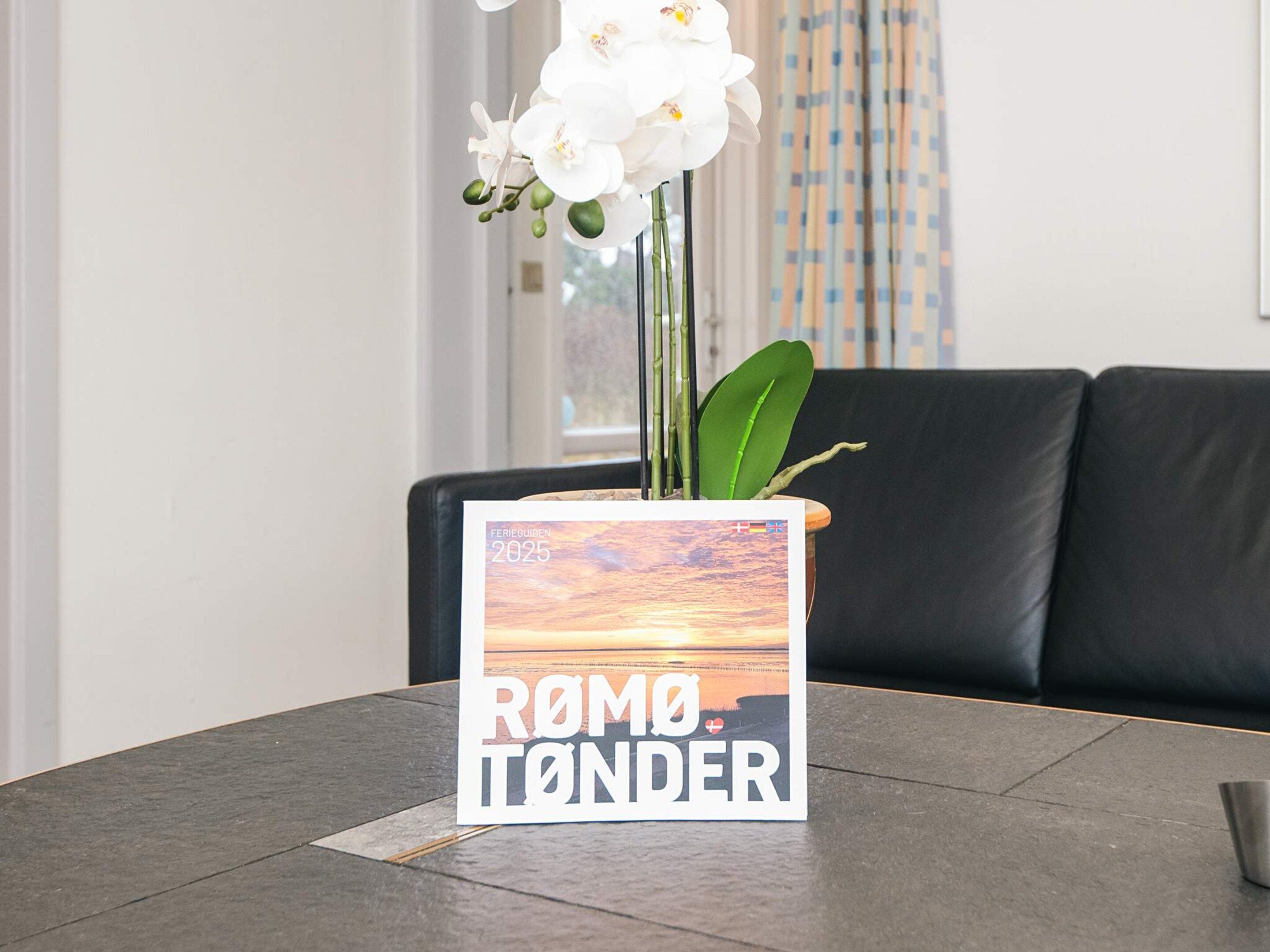 A table with a framed picture of a sunset and a sign that reads 'ROMO TÖNDER'.
