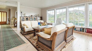 Een ruime woonkamer met een groot raam, een open haard en een gezellige zithoek.