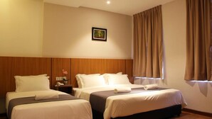 A hotel room with two beds, wooden headboards, a nightstand with a lamp, and a framed picture on the wall. - Ahyu Hotel (Kuala Lumpur)