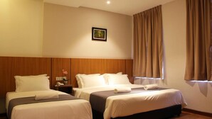 A hotel room with two beds, wooden headboards, a nightstand with a lamp, and a framed picture on the wall. - Ahyu Hotel (Kuala Lumpur)