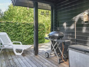 A covered outdoor area with a grill and a white lounge chair. - 4 Person Holiday Home in Glesborg (Glesborg)