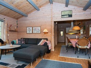 A cozy cabin interior with a sofa, dining table, and chairs. - 4 Person Holiday Home in Glesborg (Glesborg)