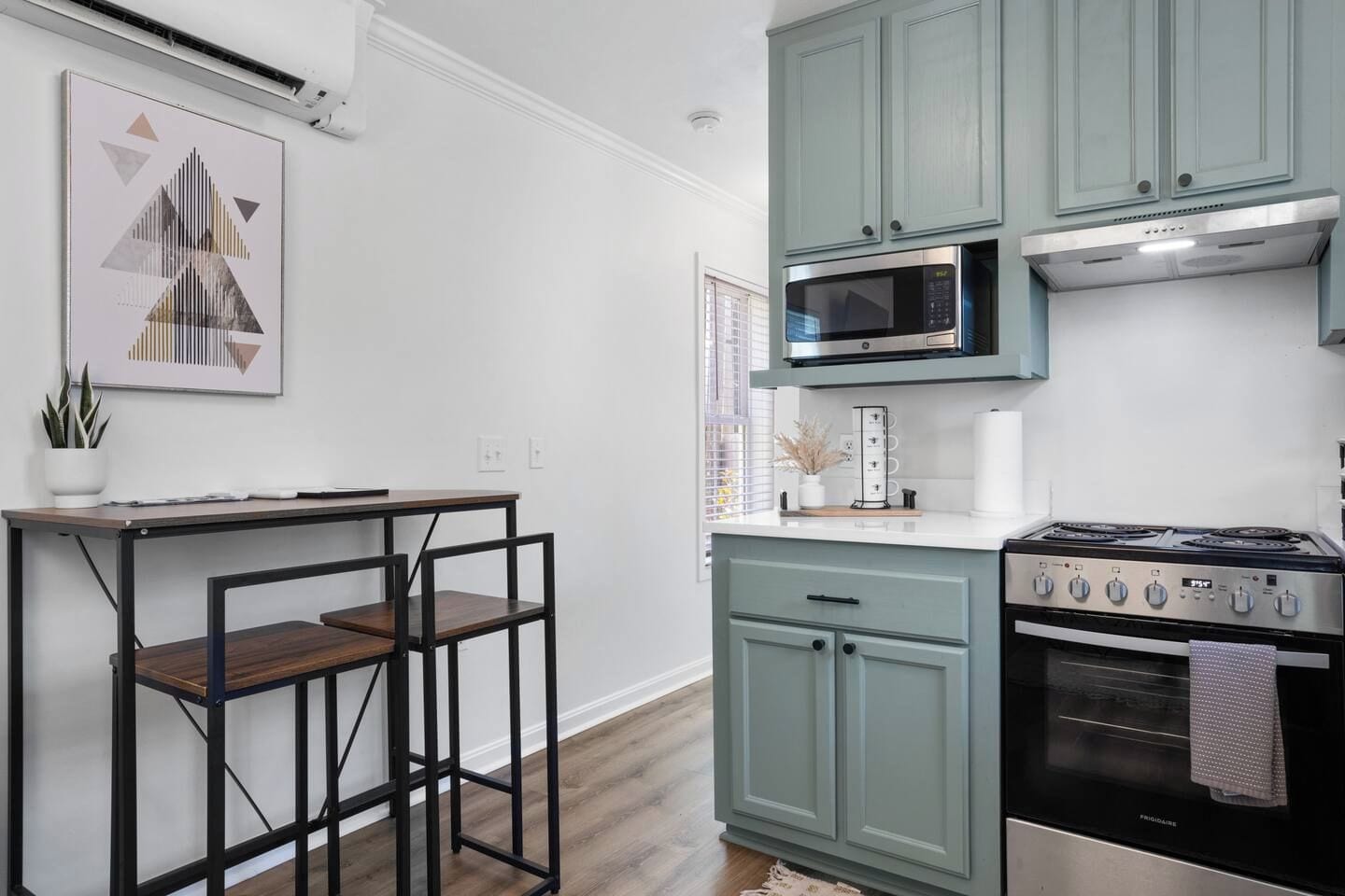 Une cuisine moderne équipée d’un four à micro-ondes, d’une cuisinière et de placards intégrés.