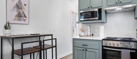 Une cuisine moderne équipée d’un four à micro-ondes, d’une cuisinière et de placards intégrés.