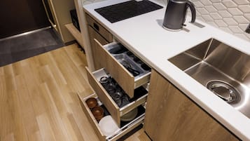 Una cucina moderna con lavello in acciaio inossidabile, bollitore e forno a incasso.