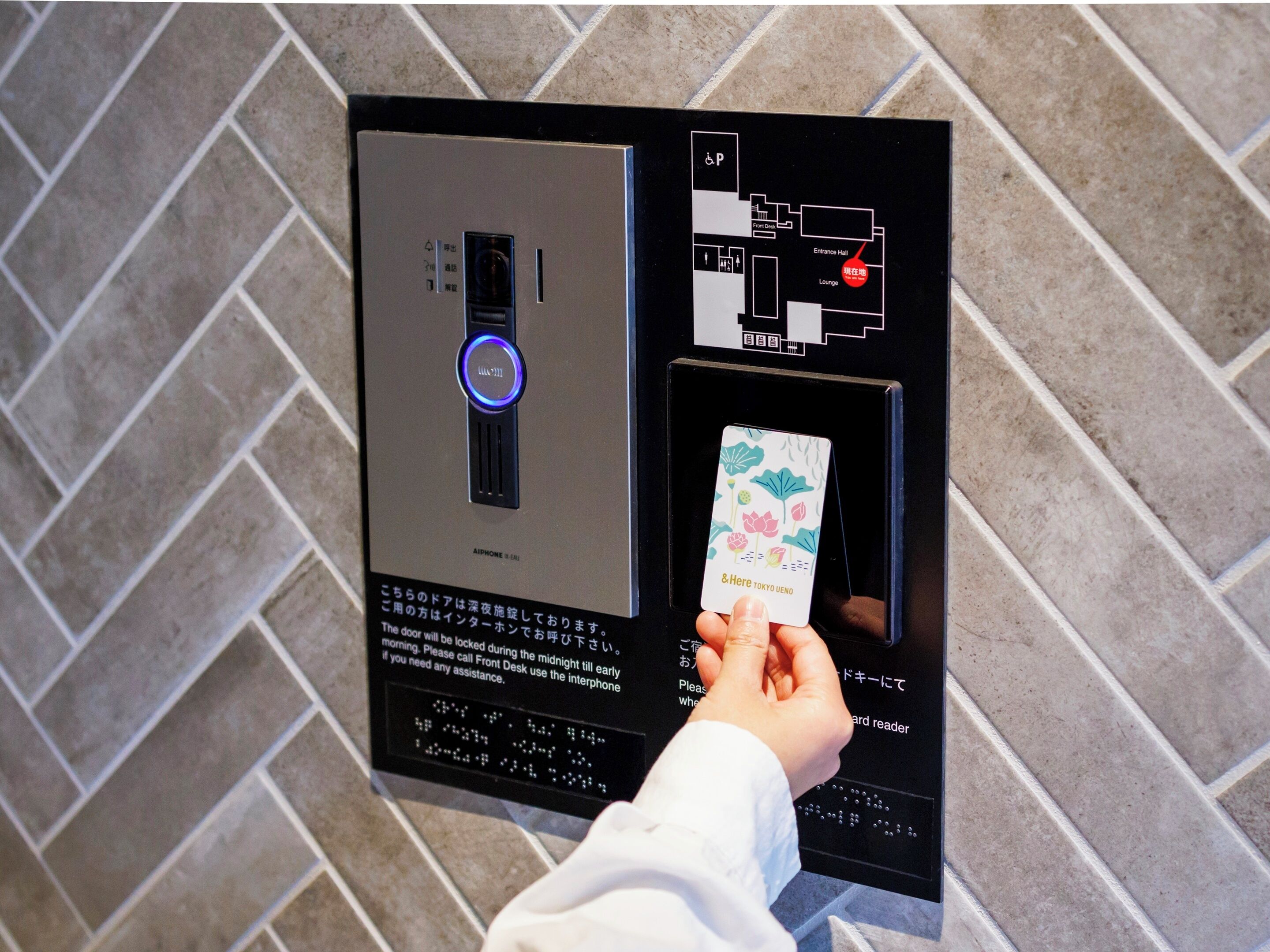 Une personne tenant une carte devant un lecteur de cartes, probablement pour accéder à une pièce ou effectuer un paiement.