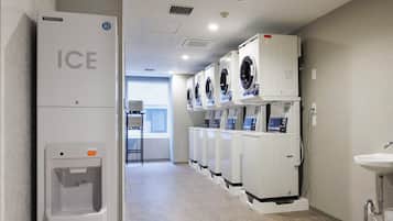 Un cuarto de lavandería con varias lavadoras y un dispensador de hielo.