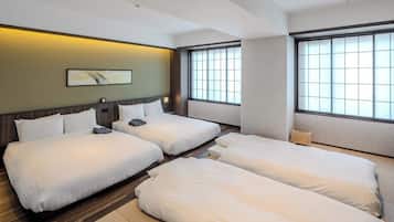 Une chambre d’hôtel avec deux lits, une grande fenêtre et une œuvre d’art accrochée au mur.