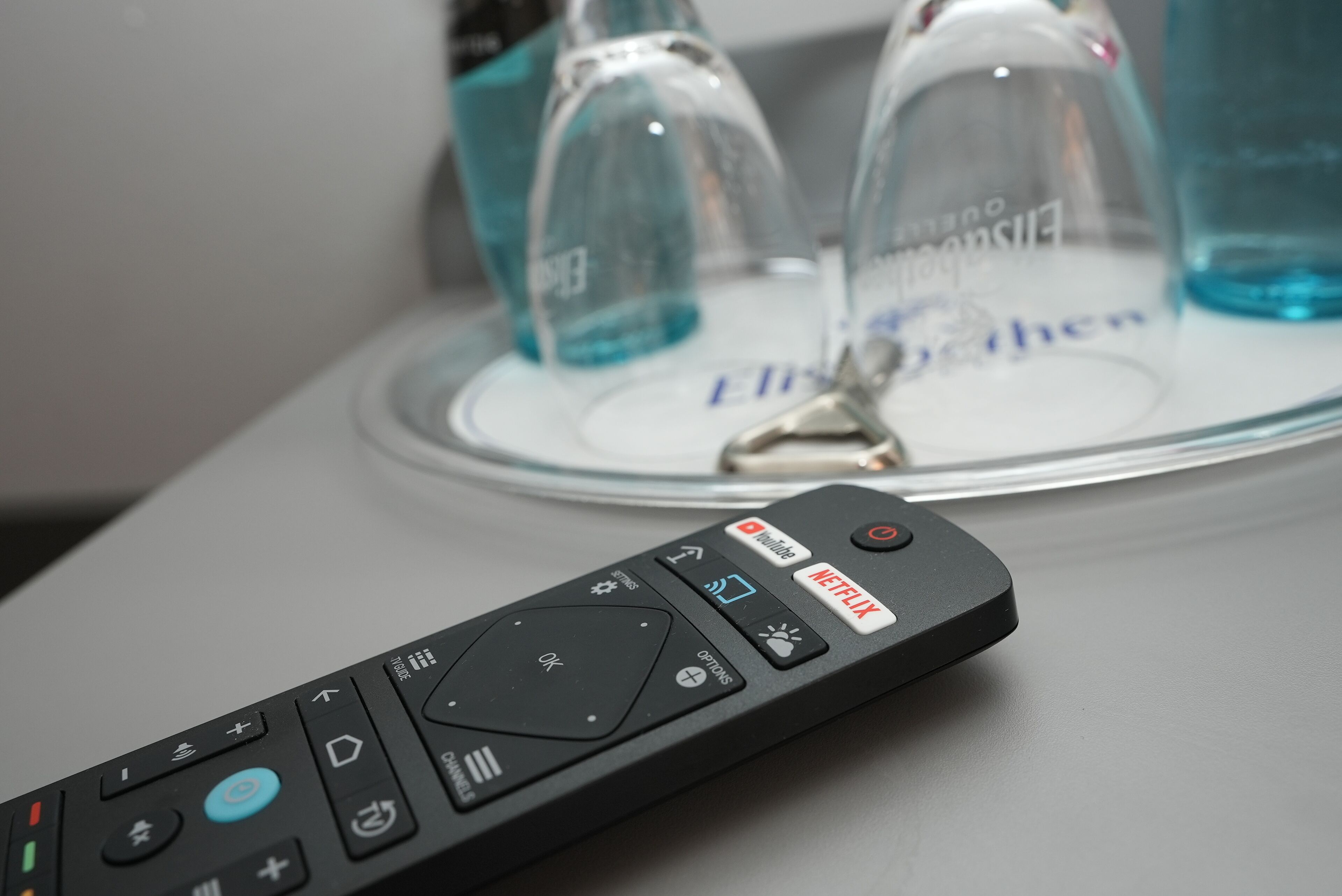 A remote control with a Netflix button on a table.