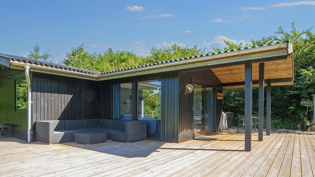 A modern outdoor deck with a covered seating area and a wooden pergola. - 6 Person Holiday Home in Ebeltoft-by Traum (Ebeltoft)