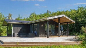 A modern outdoor structure with a covered patio area, a seating area, and a small table. - 6 Person Holiday Home in Ebeltoft-by Traum (Ebeltoft)