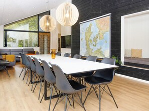 A modern conference room with a large table, chairs, a map on the wall, and large windows.