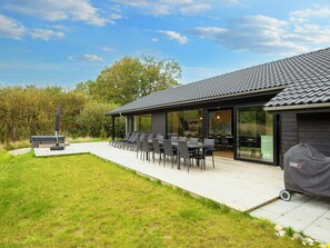 A modern outdoor patio with a grill and seating area. - 5 Star Holiday Home in Ebeltoft (Ebeltoft)