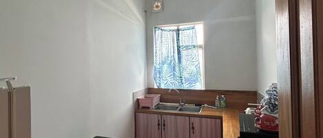 A compact kitchen with a window, sink, and a small countertop.