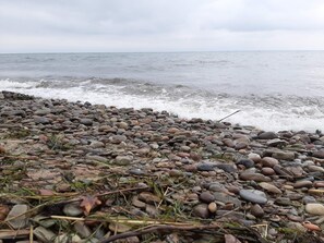 A rocky shoreline with waves crashing onto the pebbles.