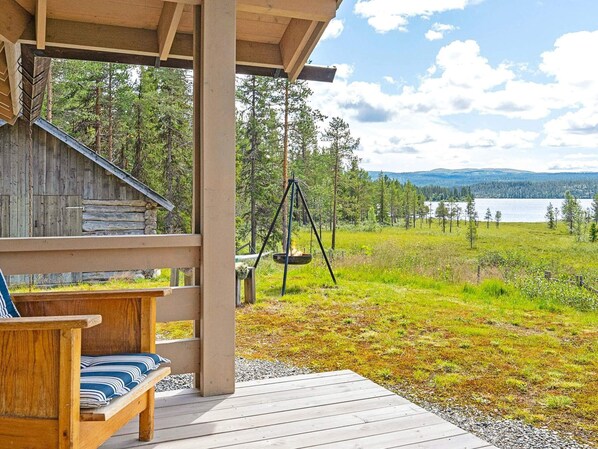 Sit on the porch and enjoy the serene surroundings of this cabin, which offers a wooden bench and swing.