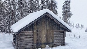 A wooden cabin with a snow-covered roof, surrounded by snow-covered trees. - 6 Person Holiday Home in Tisleidalen-by Traum (Nord-Aurdal)