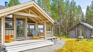A cabin with a wooden deck, a covered porch, and a small adjacent shed. - 6 Person Holiday Home in Tisleidalen-by Traum (Nord-Aurdal)