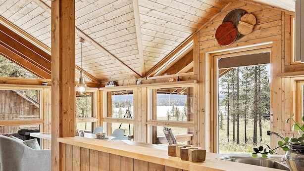 A wooden cabin interior with a kitchen area, large windows, and a view of the forest. - 6 Person Holiday Home in Tisleidalen-by Traum (Nord-Aurdal)