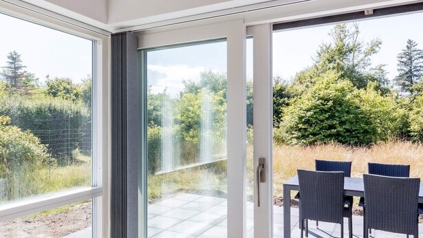 A room with a sliding glass door leading to an outdoor patio with a table and chairs. - 6 Person Holiday Home in Hjorring (Hjørring)