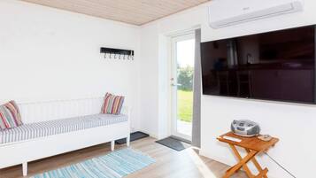 A modern room with a white sofa, a small wooden table, and a large window.