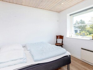 A bedroom with a bed, a chair, and a window with a view of greenery. - 6 Person Holiday Home in Hjorring (Hjørring)