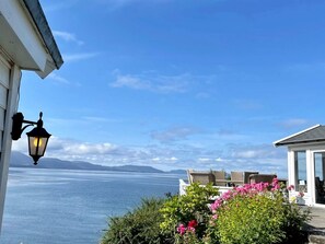 A seaside view with a lamp post, outdoor seating, and a clear sky. - 8 Person Holiday Home in Baldersheim-by Traum (Bjørnafjorden)