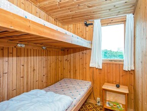 A wooden bunk bed room with a window and a small shelf. - 7 Person Holiday Home in Lemvig (Lemvig)