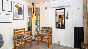 Een gezellige kamer met twee houten stoelen, een spiegel en lijstwerken aan de muur.