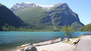 A lakeside view with boats, a dock, and a mountain backdrop. - 7 Person Holiday Home in Oppstryn (Stryn)
