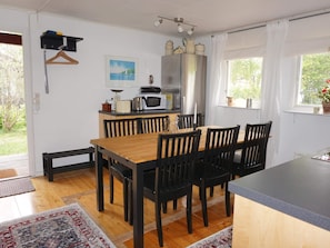 A compact kitchen with a dining area, wooden table, and chairs. - 6 Person Holiday Home in Monsteras (Monsteras)