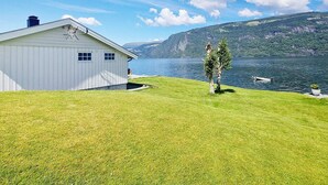 A white building with a sloped roof, a small window, and a chimney. - 4 Person Holiday Home in Utvik-by Traum (Stryn)