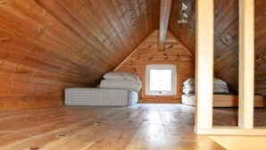 A wooden attic bedroom with a sloped ceiling, a window, and a bed with pillows. - 4 Person Holiday Home in Maloy-by Traum (Kinn)