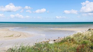 A beach with clear skies and calm waters. - 8 Person Holiday Home in Hadsund (Hadsund)