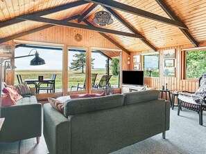 Um interior aconchegante com uma janela grande, um sofá e uma televisão.