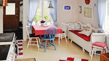 A cozy room with a dining table, chairs, a sofa, and a bed.