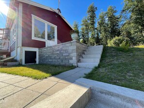 A red building with a stone wall and a concrete staircase leading to a garage. - 4 Star Holiday Home in Bruzaholm (Bruzaholm)