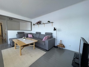 A modern living room with a grey sofa, a wooden coffee table, and a floor lamp. - 4 Star Holiday Home in Bruzaholm (Bruzaholm)