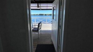 Una puerta que da a una terraza con vistas al agua y un muelle.